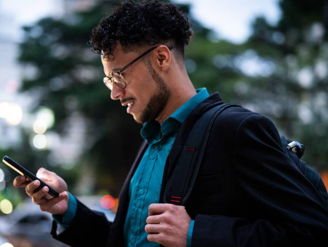 man looking at phone paying medical bill